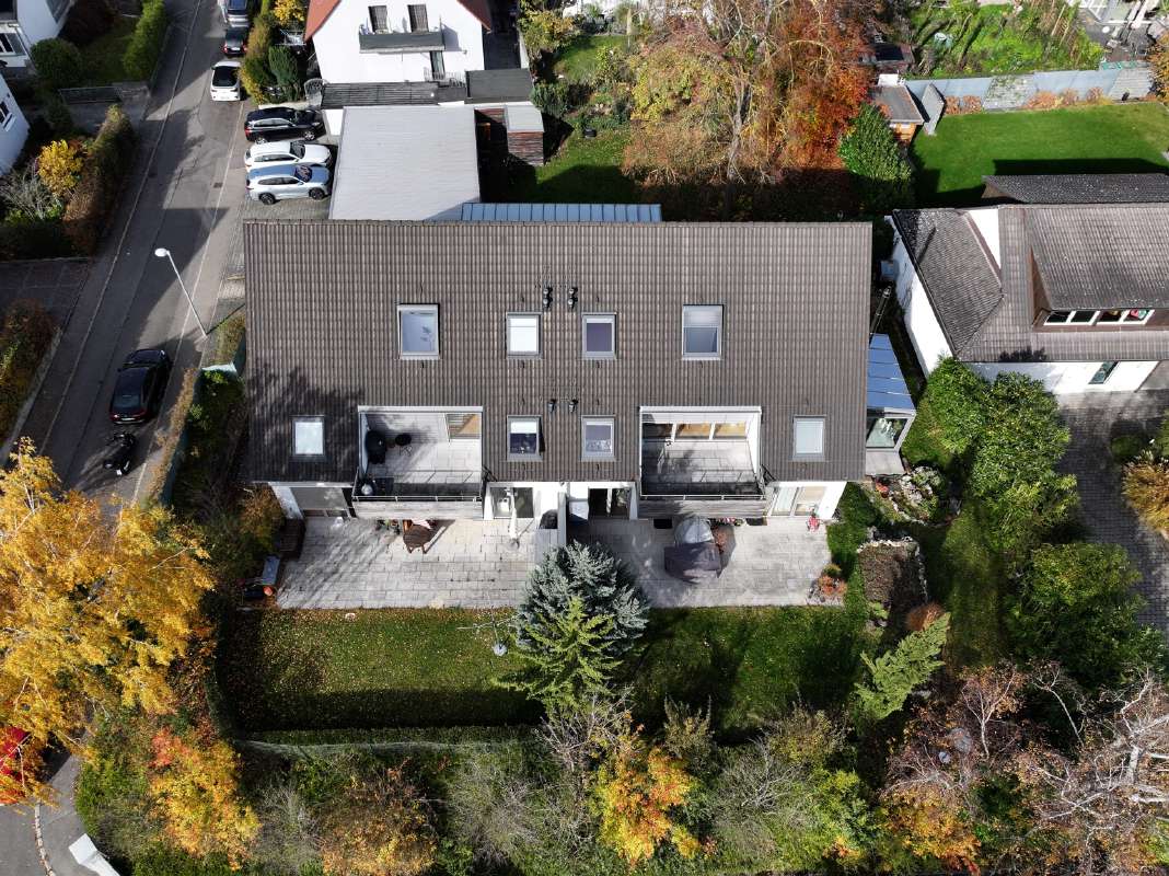 Luftaufnahme eines Mehrfamilienhauses mit sichtbaren Hausnummern auf dem Dach